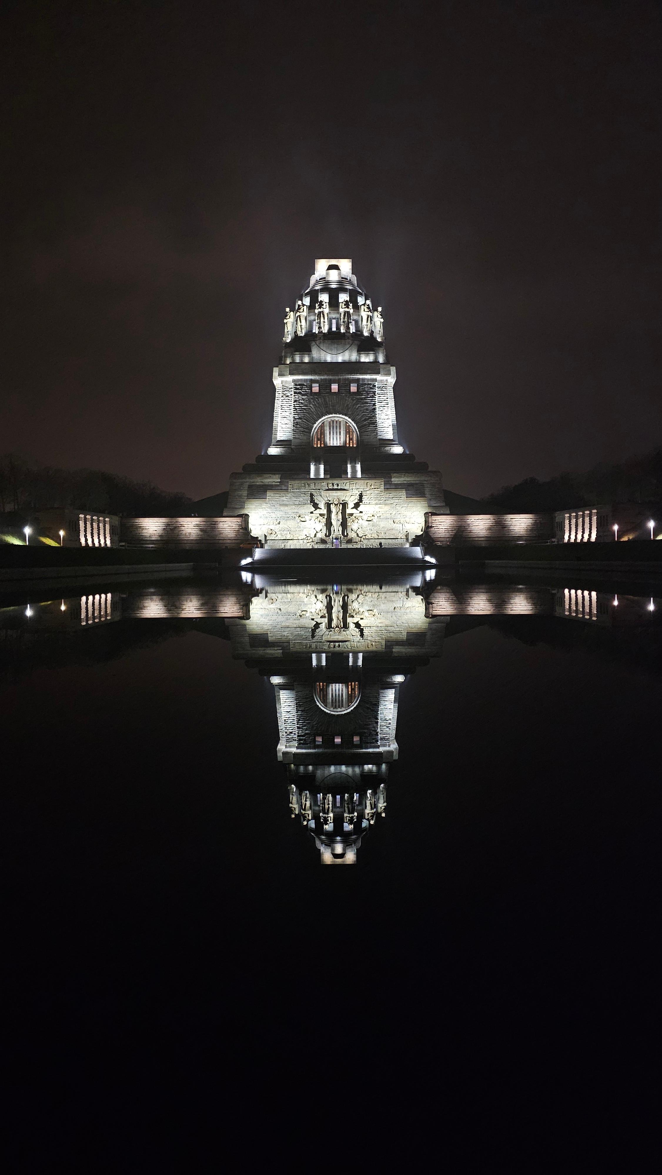 Völkerschlachtdenkmal Leipzig bei Nacht beleuchtet mit Spiegelung im Wasserbecken 